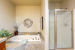 The ensuite features both a luxurious soaking tub and shower